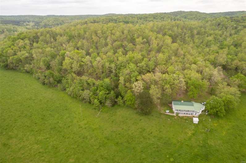Birds eye view of property with a wooded view
