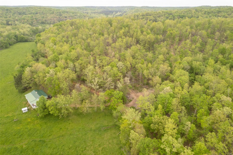 Aerial view featuring a wooded view