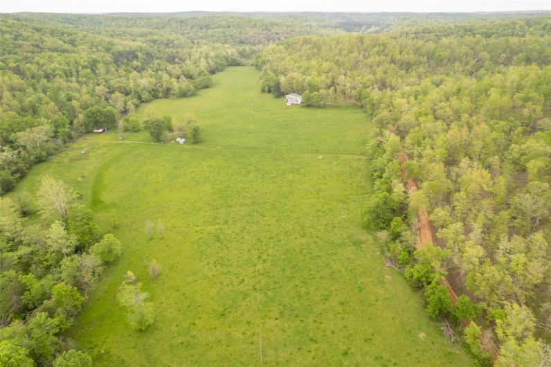 Birds eye view of property with a wooded view and a rural view