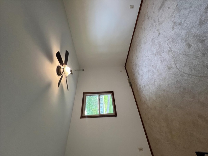 Carpeted spare room with visible vents, baseboards, and a ceiling fan