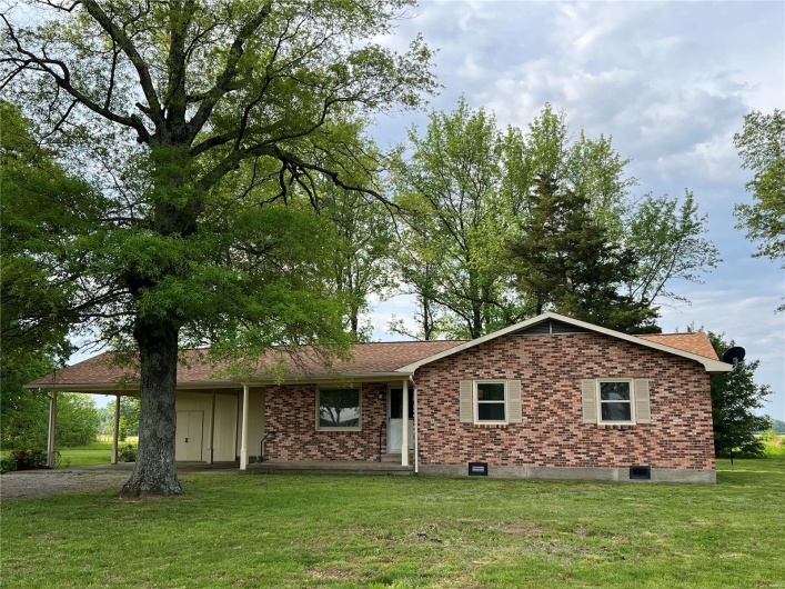 View of front of house with driveway, a shingled roof, brick siding, and a front yard