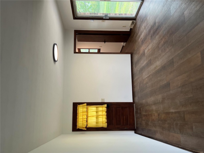 Empty room with baseboards, visible vents, and dark wood-type flooring