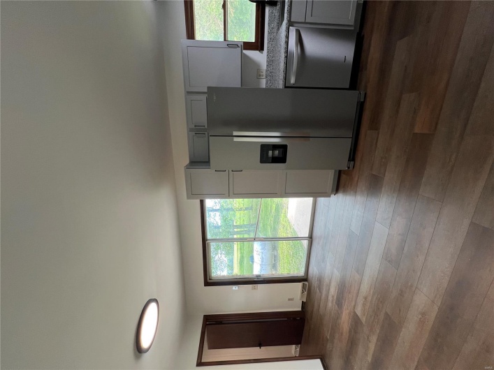 Kitchen with a wealth of natural light, dishwashing machine, gray cabinets, and refrigerator