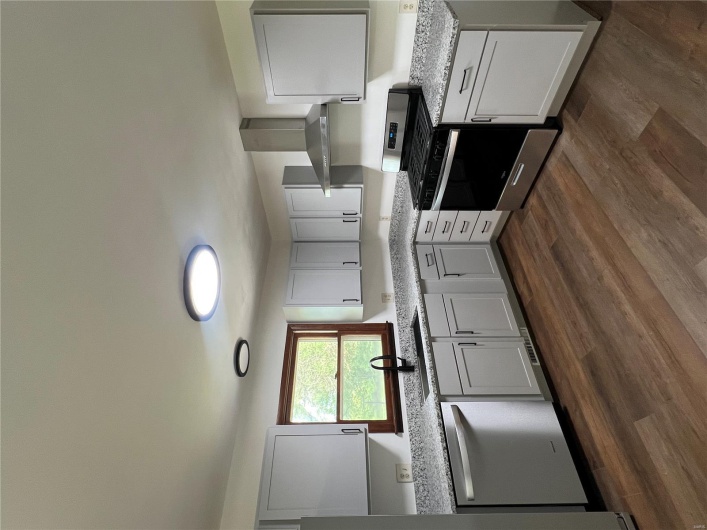 Kitchen featuring exhaust hood, dishwasher, stove, refrigerator, and a sink