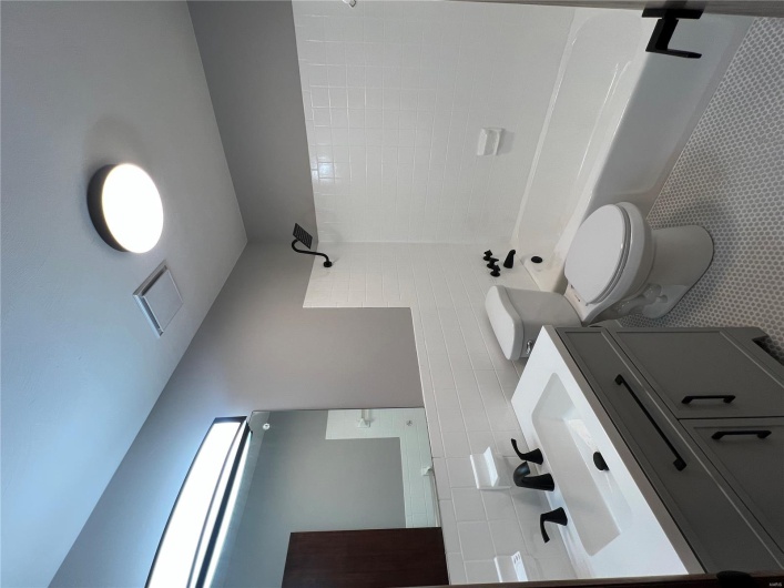 Full bath with tile walls, toilet, vanity, visible vents, and  shower combination