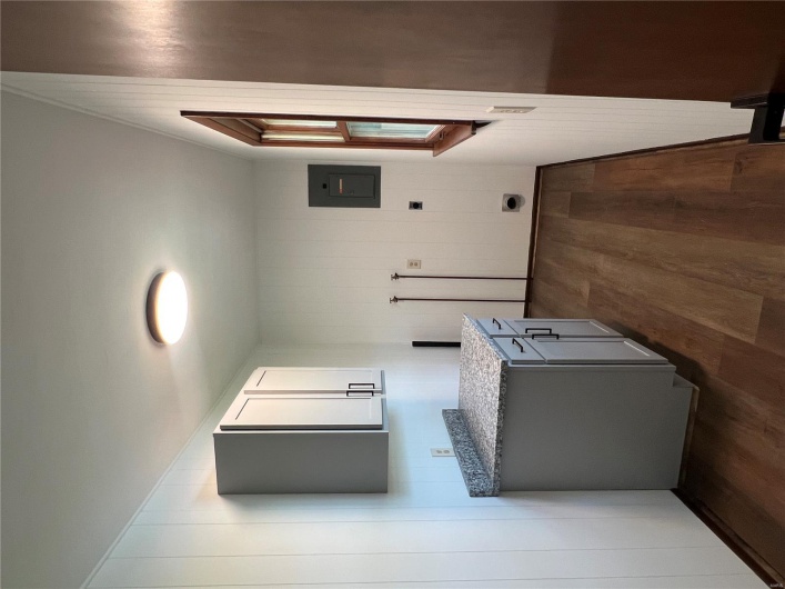 Washroom featuring electric panel, cabinet space, and dark wood-type flooring