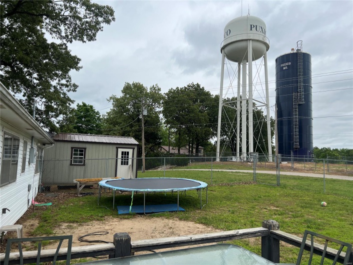 View of yard featuring a trampoline and fence
