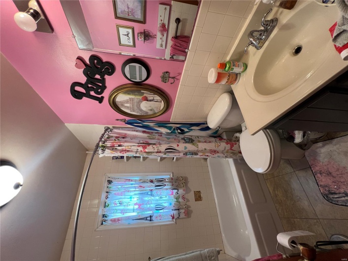 Bathroom featuring tile patterned floors, toilet, shower / bath combo, and vanity