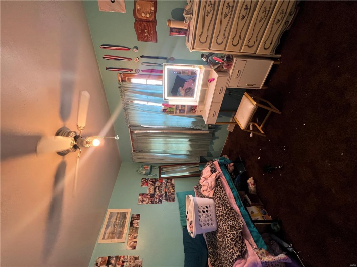 Bedroom featuring ceiling fan and dark colored carpet