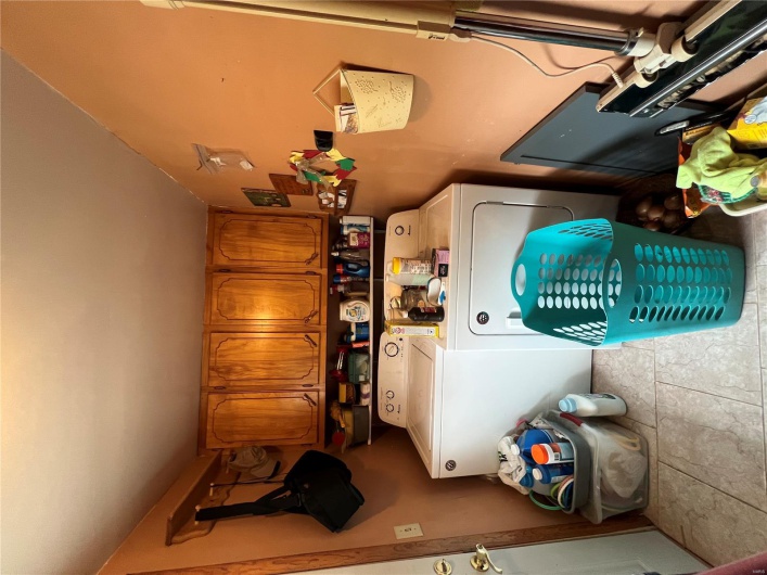 Clothes washing area with cabinet space, independent washer and dryer, and light tile patterned flooring