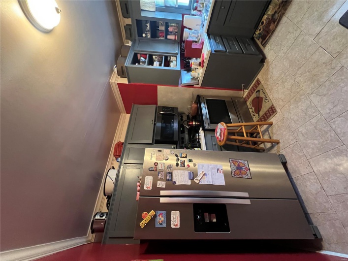 Kitchen featuring open shelves, ornamental molding, gray cabinets, range, and fridge