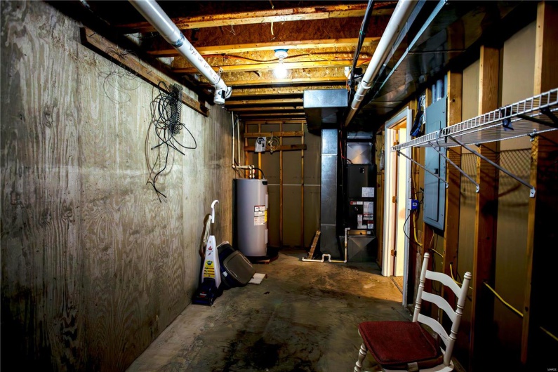 Unfinished basement with water heater and heating unit