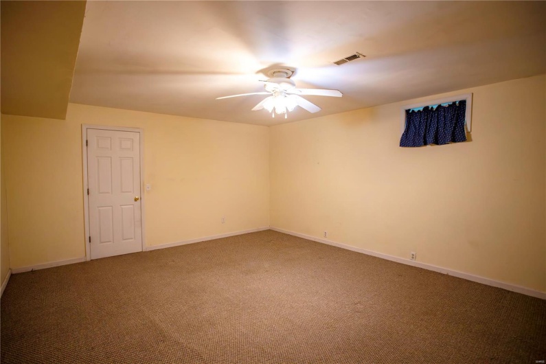 Carpeted spare room featuring baseboards, a ceiling fan, and visible vents