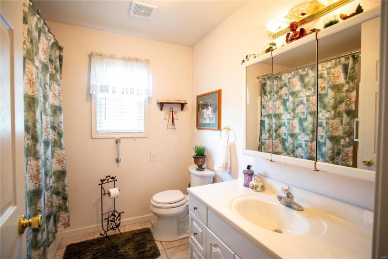 Bathroom featuring toilet, vanity, visible vents, tile patterned flooring, and baseboards