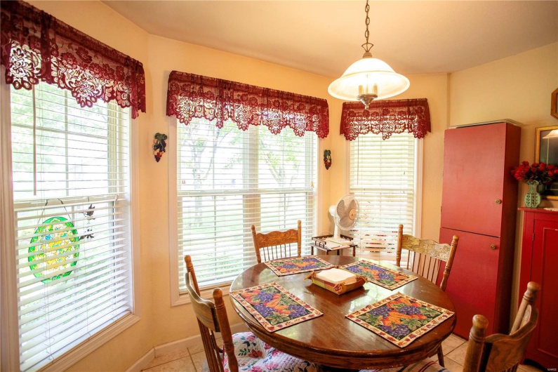 Dining room with light tile patterned floors, baseboards, and a healthy amount of sunlight