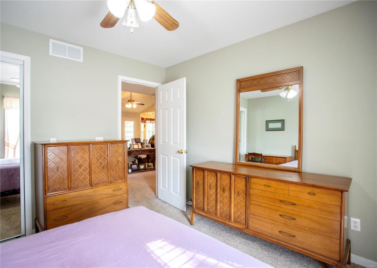 Bedroom with ceiling fan, carpet flooring, and visible vents