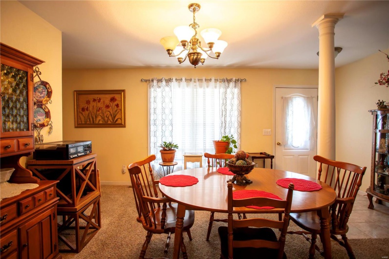 Dining room with a chandelier, baseboards, and decorative columns