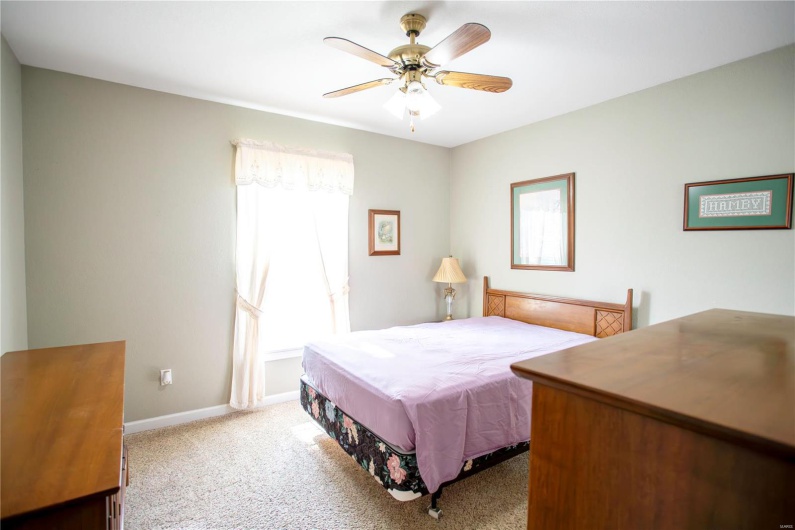 Carpeted bedroom with baseboards and a ceiling fan