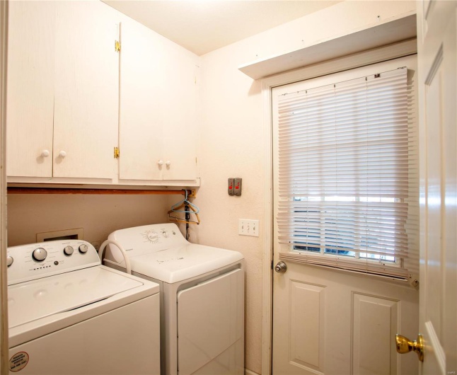 Laundry area with separate washer and dryer and cabinet space
