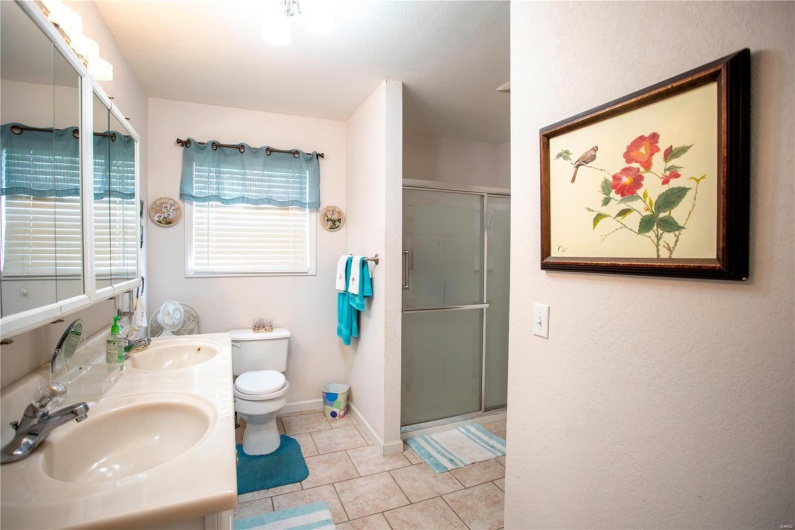 Full bathroom with a sink, toilet, a stall shower, and tile patterned floors
