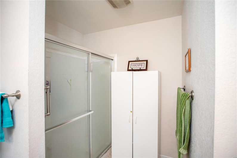 Full bath with a stall shower and visible vents