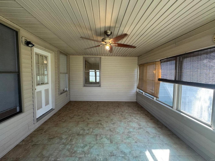 Unfurnished sunroom with wood ceiling and ceiling fan