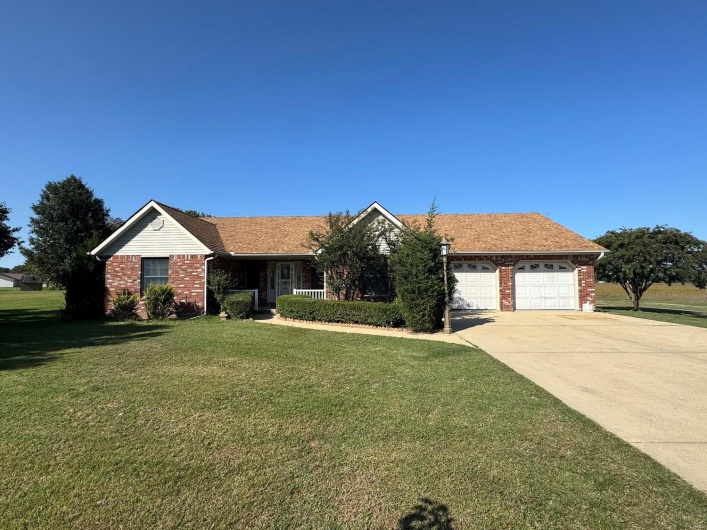 Single story home with a garage and a front yard