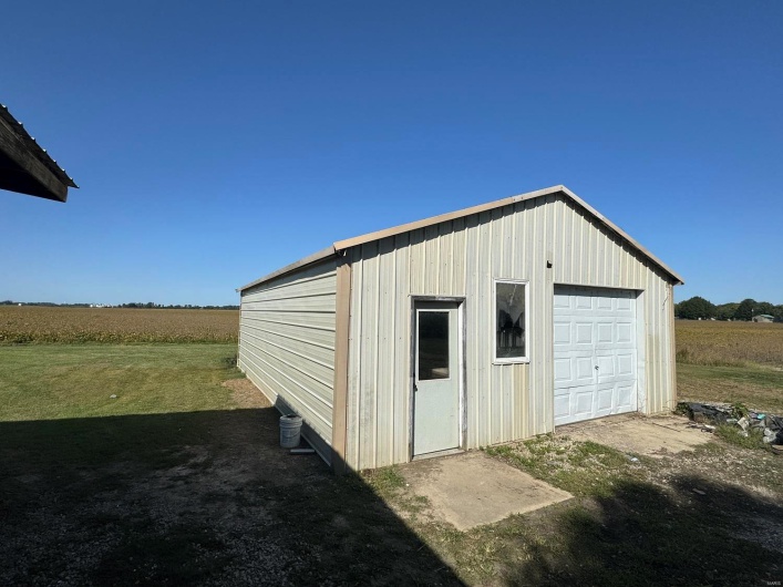 Garage featuring a rural view and a lawn