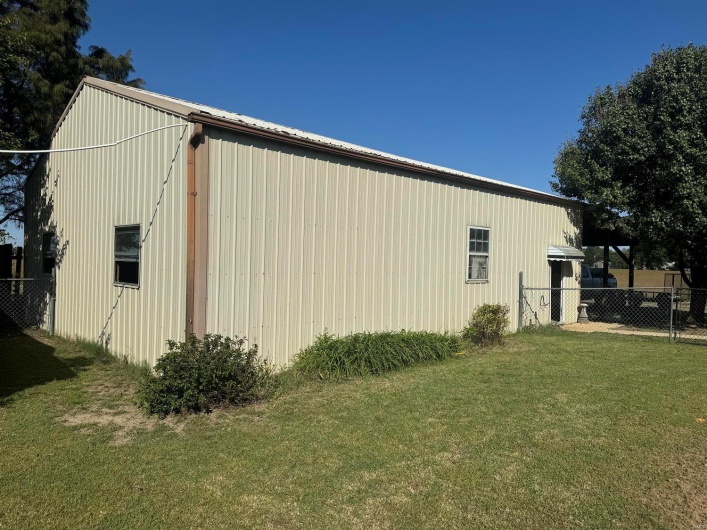 View of side of home with a yard