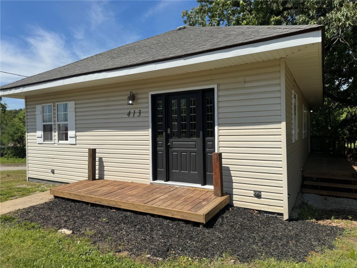 Doorway to property featuring roof with shingles