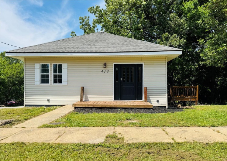 Bungalow-style house with a front lawn, roof with shingles, and a wooden deck