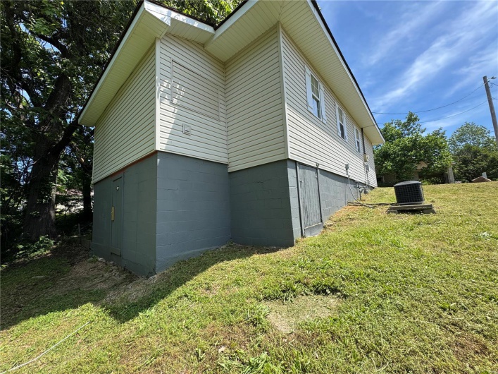 View of property exterior featuring a yard and central air condition unit
