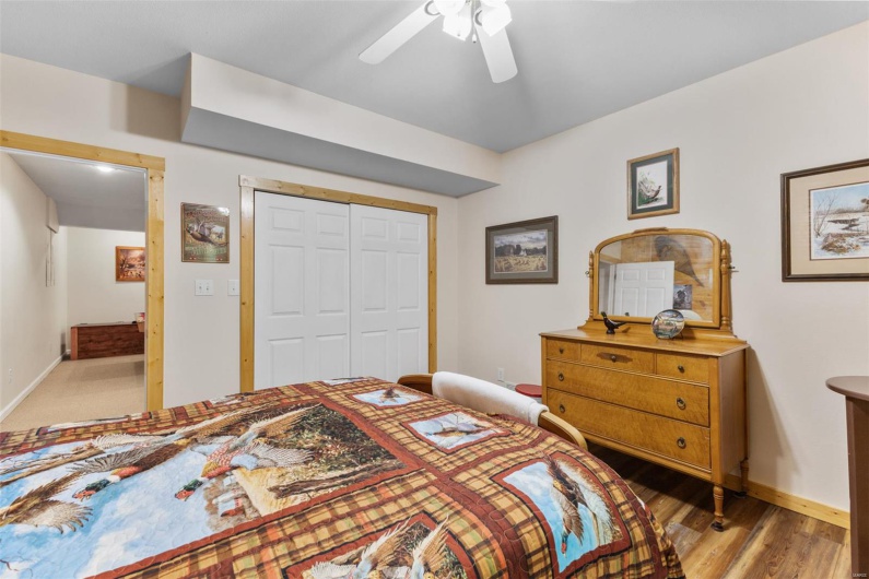 Bedroom featuring light wood finished floors, a closet, baseboards, and a ceiling fan