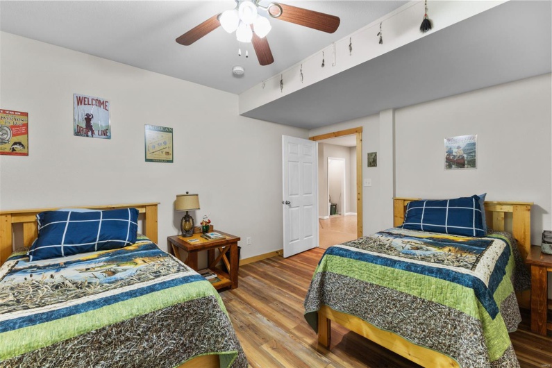 Bedroom featuring a ceiling fan, baseboards, and wood finished floors