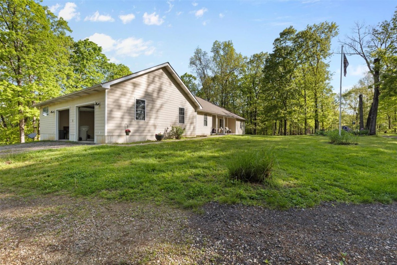 View of side of property featuring a yard, driveway, and a garage