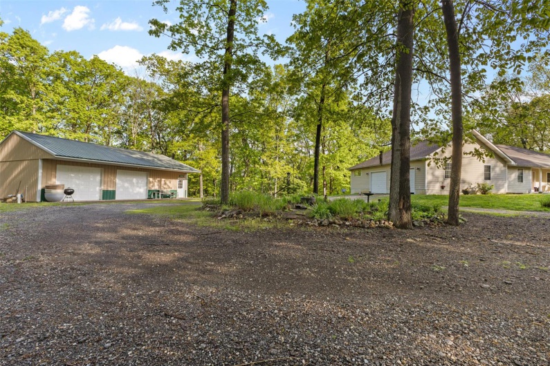 View of yard with a detached garage and an outbuilding