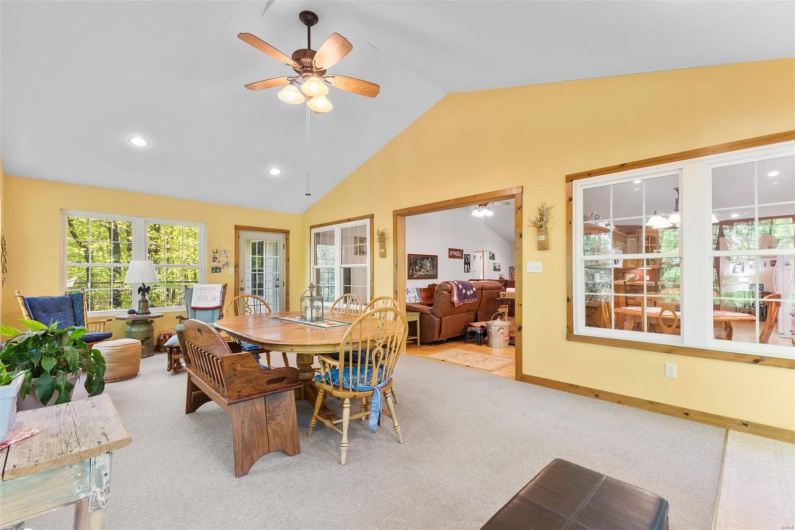 Carpeted dining space featuring ceiling fan, lofted ceiling, and recessed lighting