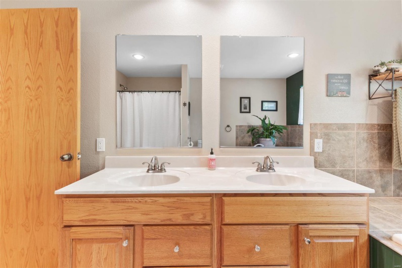 Bathroom featuring a shower with curtain, double vanity, and a sink