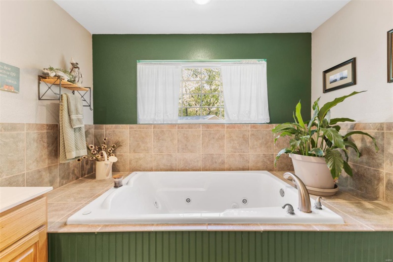 Full bathroom with a whirlpool tub and vanity
