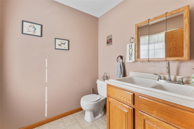 Bathroom with vanity, toilet, baseboards, and tile patterned floors