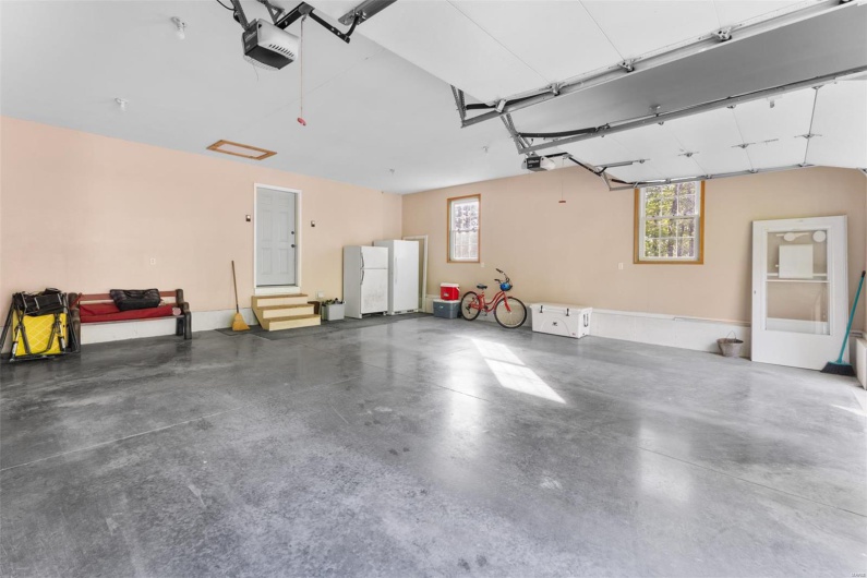 Garage with freestanding refrigerator and a garage door opener