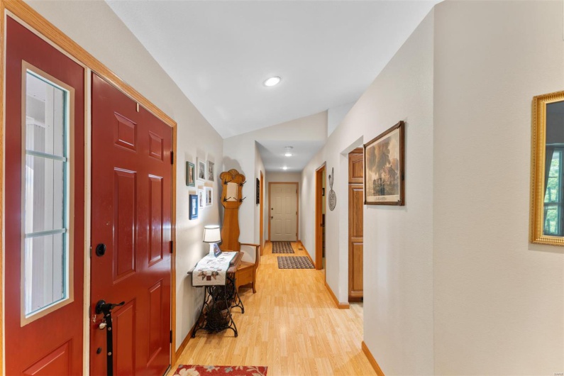 Entryway with baseboards, recessed lighting, lofted ceiling, and light wood-type flooring