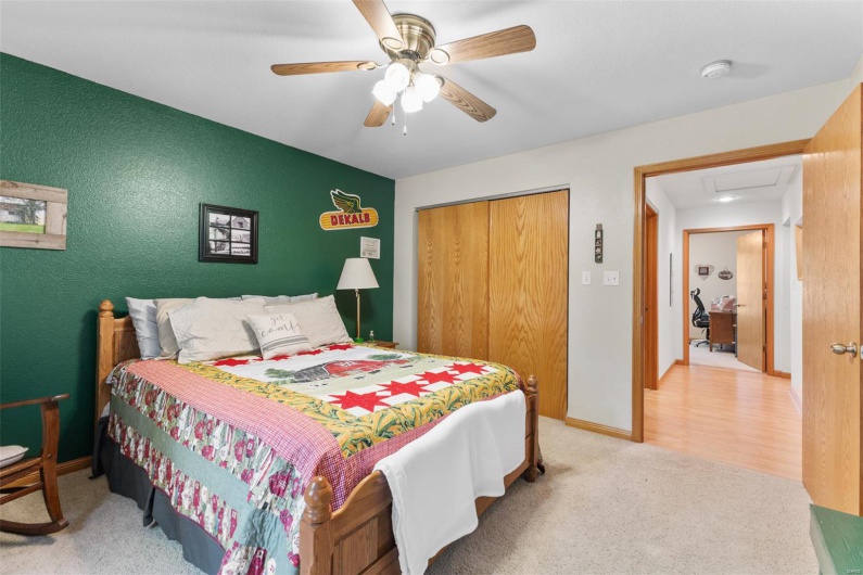 Carpeted bedroom featuring a ceiling fan, a closet, and a textured wall