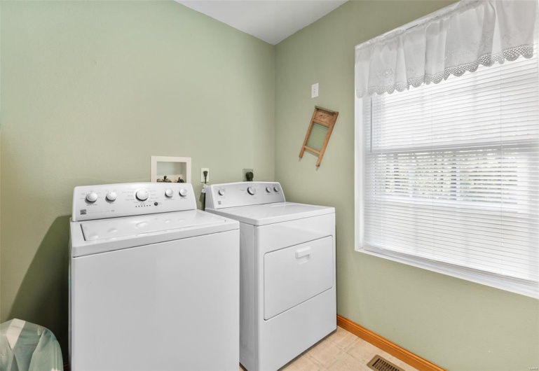 Laundry area with separate washer and dryer, laundry area, and baseboards