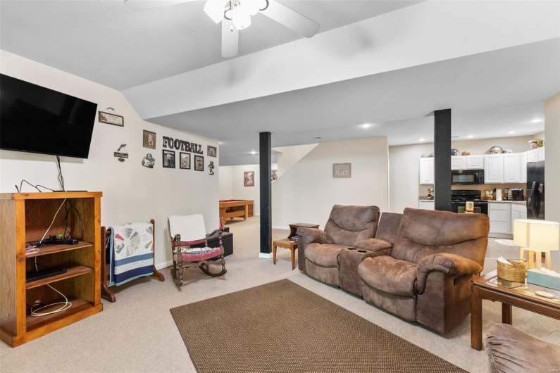 Living area with a ceiling fan, light carpet, and recessed lighting