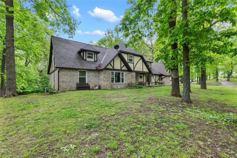 View of front of property featuring a front lawn, brick siding, and roof with shingles