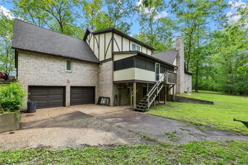 View of front of home featuring a garage, a shingled roof, brick siding, and driveway