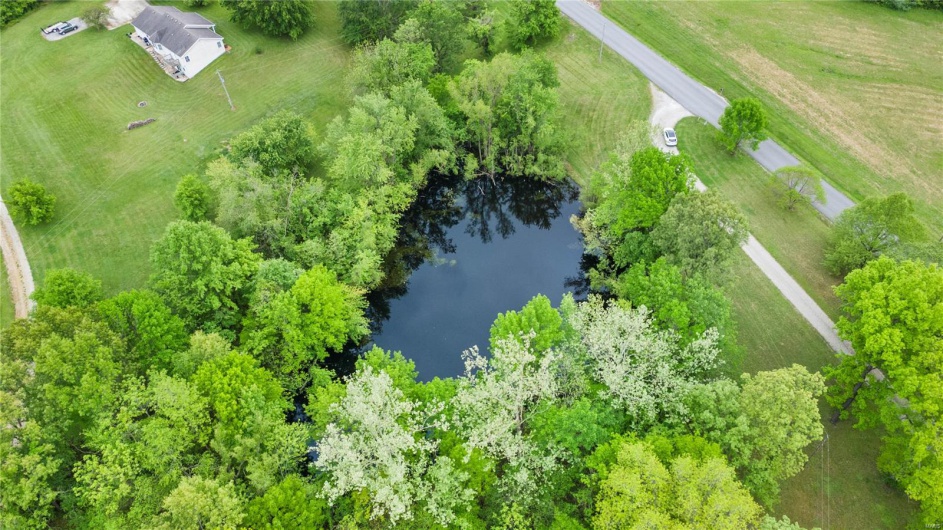 Birds eye view of property with a water view and a rural view
