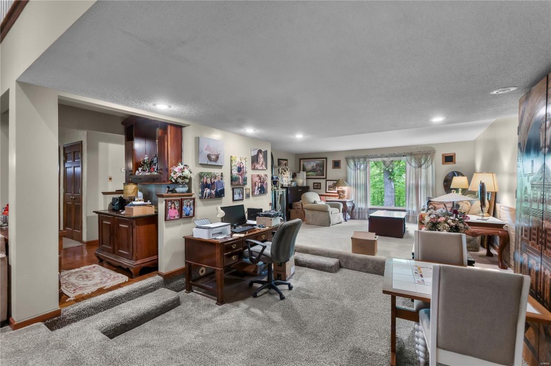 Home office with a textured ceiling, carpet floors, and recessed lighting