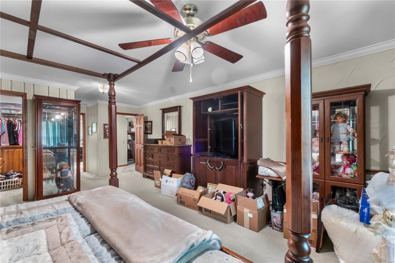 Bedroom with crown molding, carpet flooring, and ceiling fan